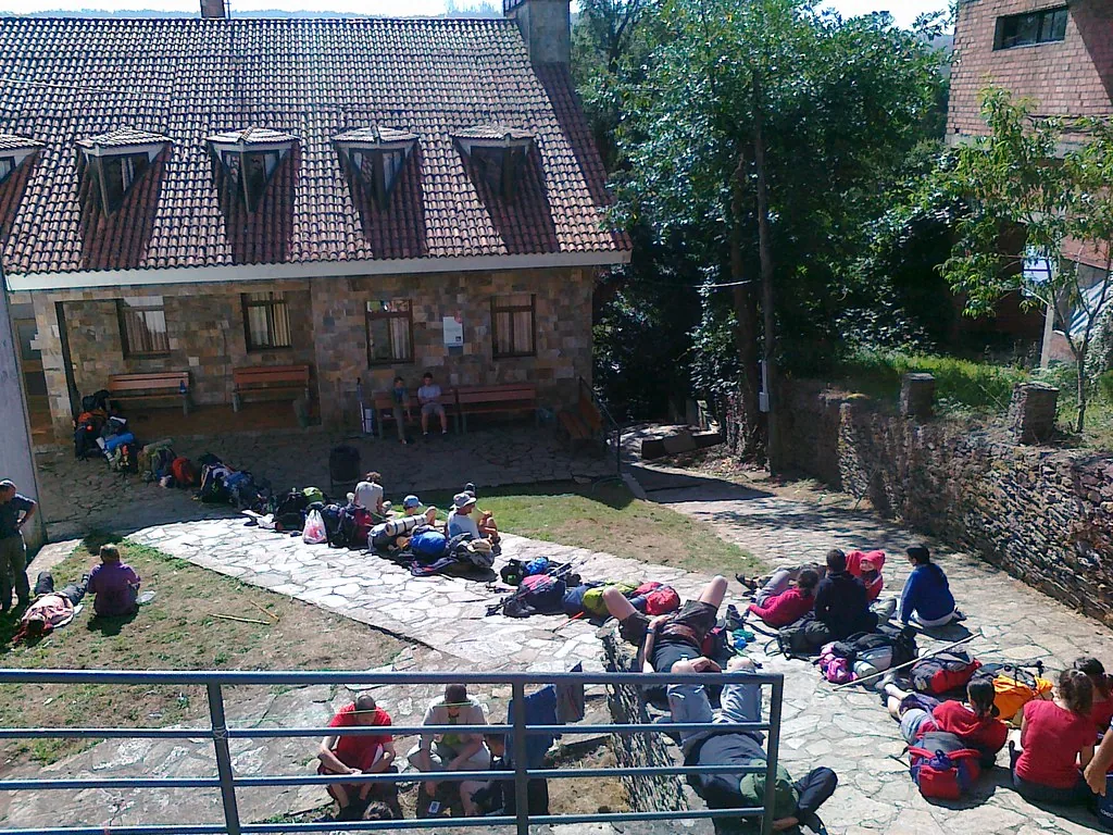 Peregrinos descansando junto a sus mochilas en O Pedrouzo